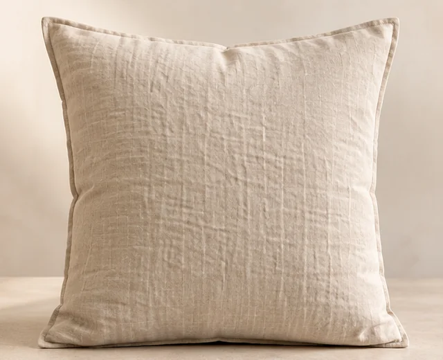 Coussin en lin sable présenté de face sur un fond clair.