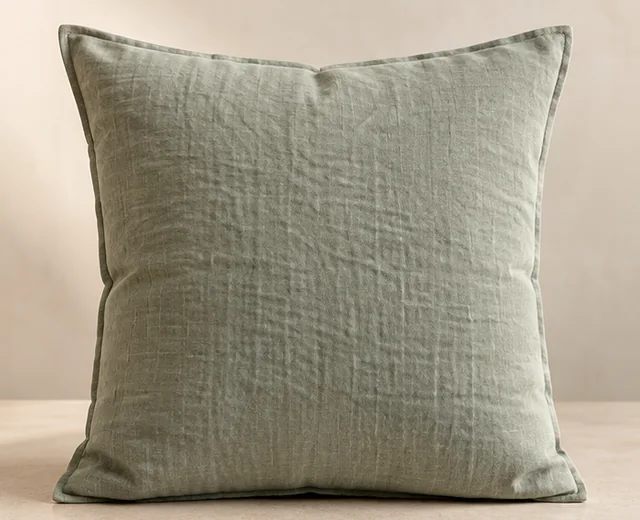 Coussin en lin vert sauge présenté de face sur un fond clair.