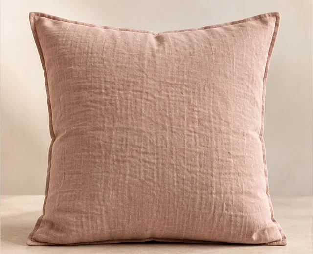 Coussin en lin rose poudré présenté de face sur un fond clair.